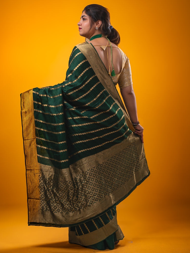 Crape fancy saree dark green color allover zari weaves & zari border with zari pallu and plain blouse