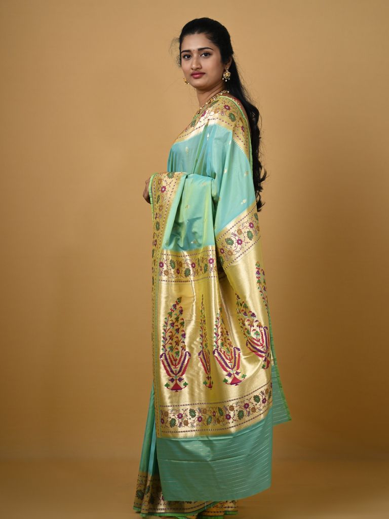 Banaras pattu fancy saree in light blue color allover zari motifs and paithani border paired with plain blouse