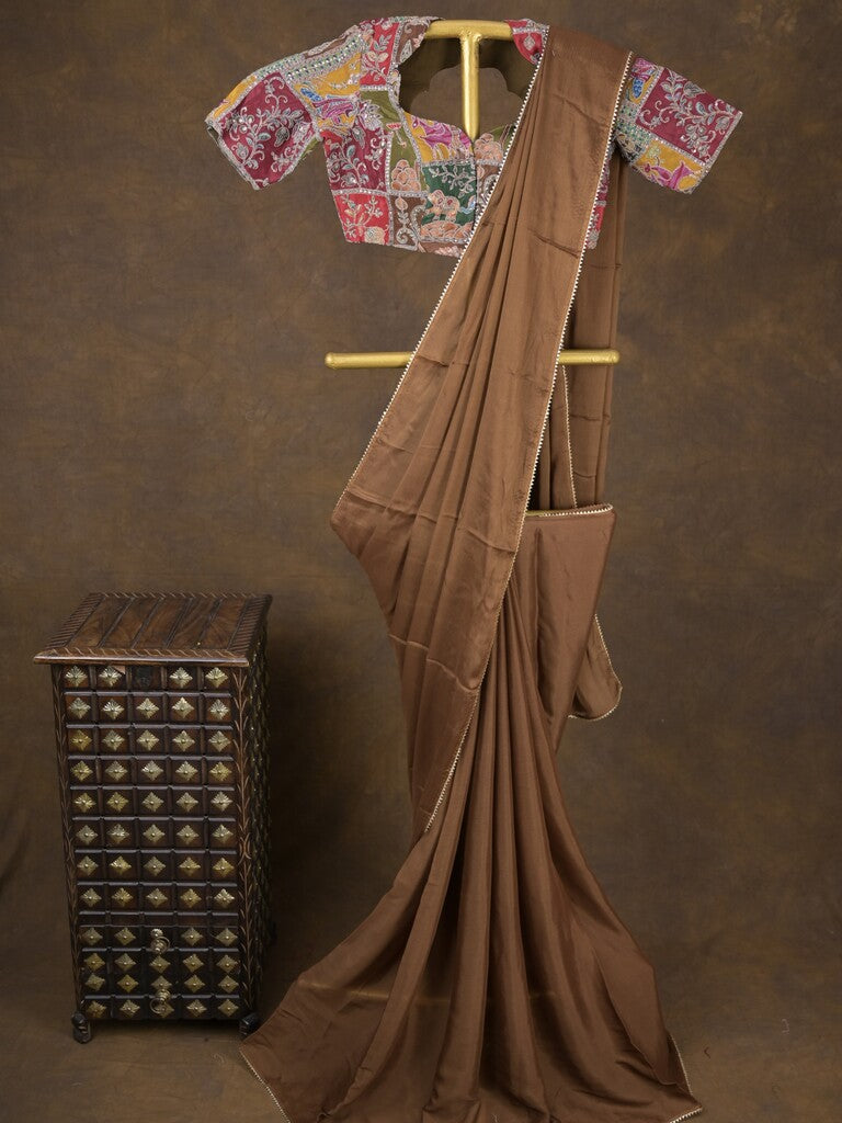 Brown color chinnon plain fancy saree with fancy border and embroidery stitched blouse