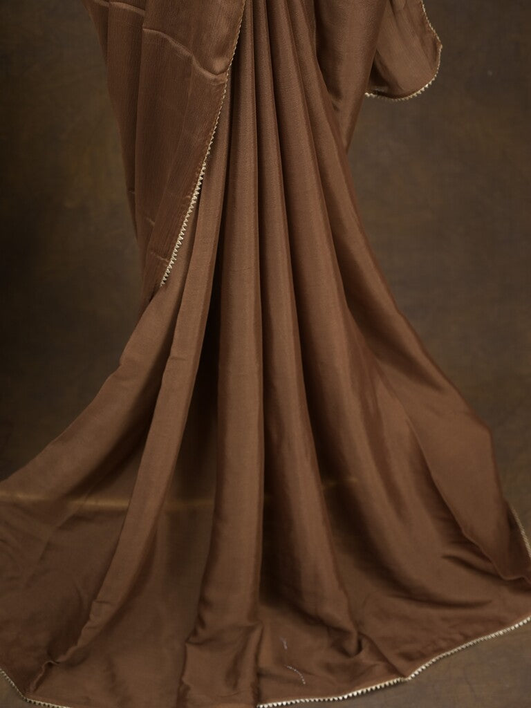 Brown color chinnon plain fancy saree with fancy border and embroidery stitched blouse