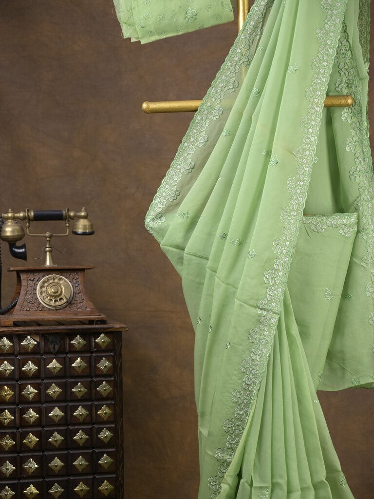 Organza fancy saree light pista green color allover embroidered motifs & cutwork border with running pallu and self blouse